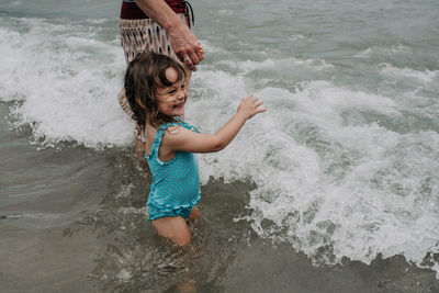 Full length of shirtless boy playing in water at beach