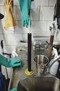 Cropped image of worker standing by beakers with thermometers at brewery