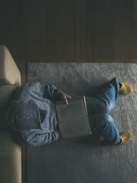 Low section of woman sitting on sofa at home