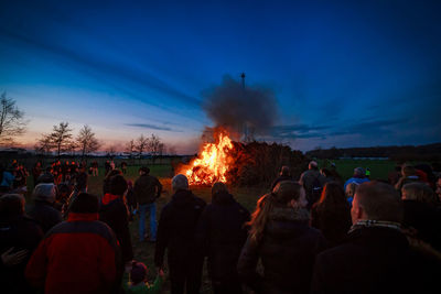 People around bonfire during easter at dusk