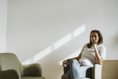 Portrait of young woman sitting on chair