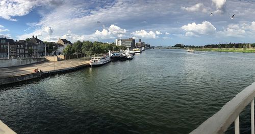 Scenic view of river against sky in city