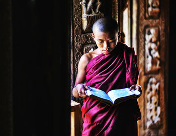 Full length of a girl sitting on book