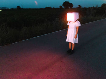 Rear view of woman walking on road