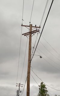 Low angle view of electricity pylon against sky