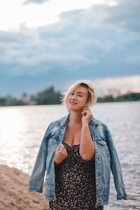 Portrait of young woman standing at beach