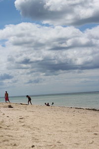 Scenic view of beach against cloudy sky