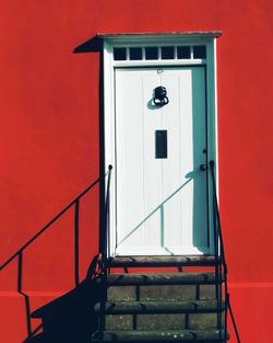 Low angle view of door against red wall