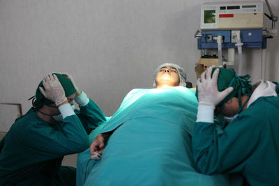 Rear view of people lying in kitchen