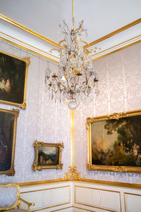 Low angle view of chandelier hanging on ceiling of building