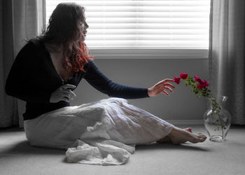 Woman sitting by window at home