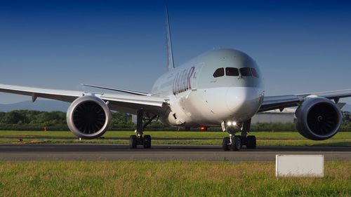 Airplane on runway against clear sky