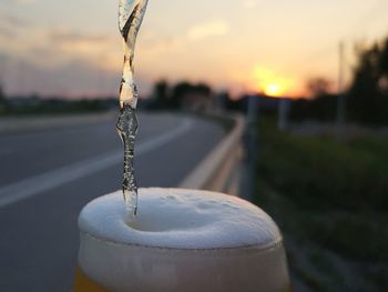 Close-up of beer bubbles by the local road  during sunset. 