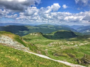 Scenic view of green landscape against sky