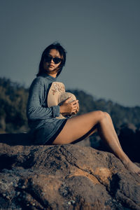 Woman sitting on rock on the beach