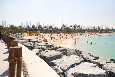 Group of people in swimming pool against buildings in city