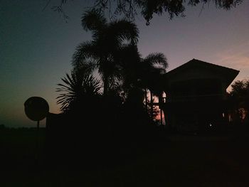 Silhouette trees against clear sky at sunset