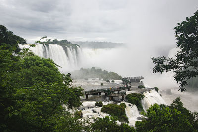 Scenic view of iguacu falls against cloudy sky