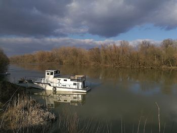 Boat moored in lake against sky