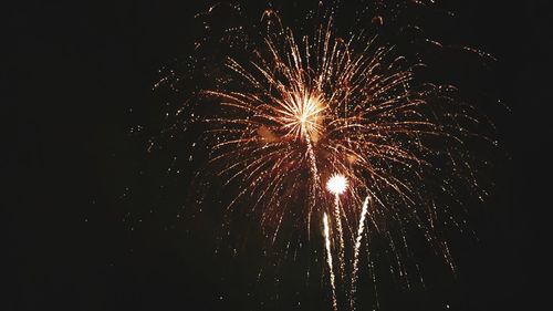 Low angle view of firework display at night