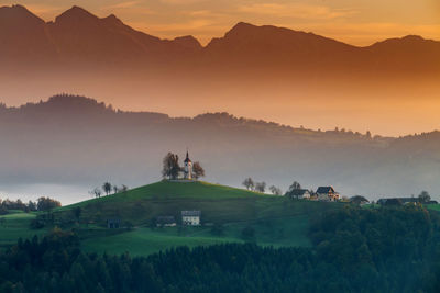 Scenic view of landscape against mountain during sunset