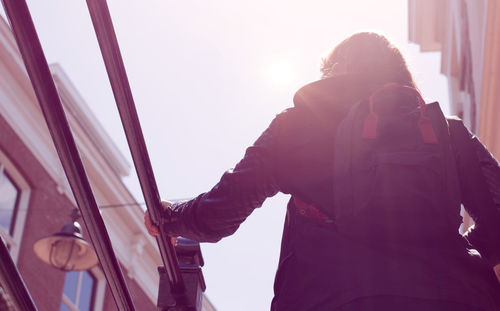 Low angle view of woman standing against sky