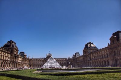 View of buildings against clear blue sky