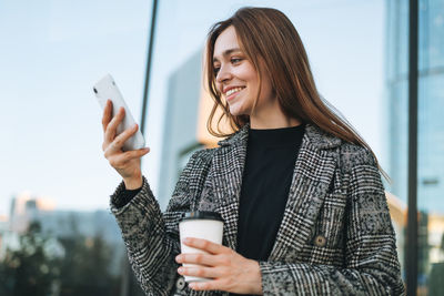 Portrait of young woman standing against sky