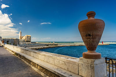 Built structure by sea against blue sky