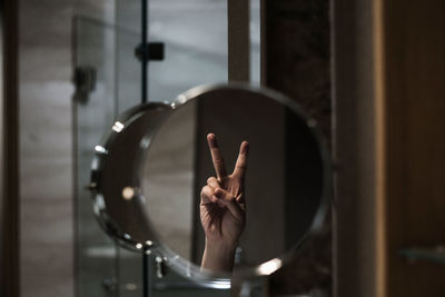 Reflection of person hand on glass, peace symbols 