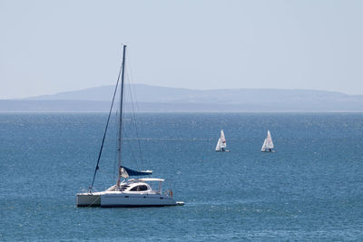 Sailboats on sea against sky