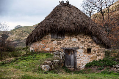 Old house on mountain against sky