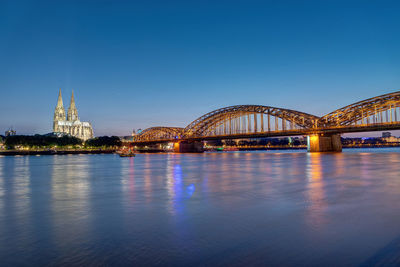 The river rhine, the cologne cathedral and the hohenzolllern bridge at dusk