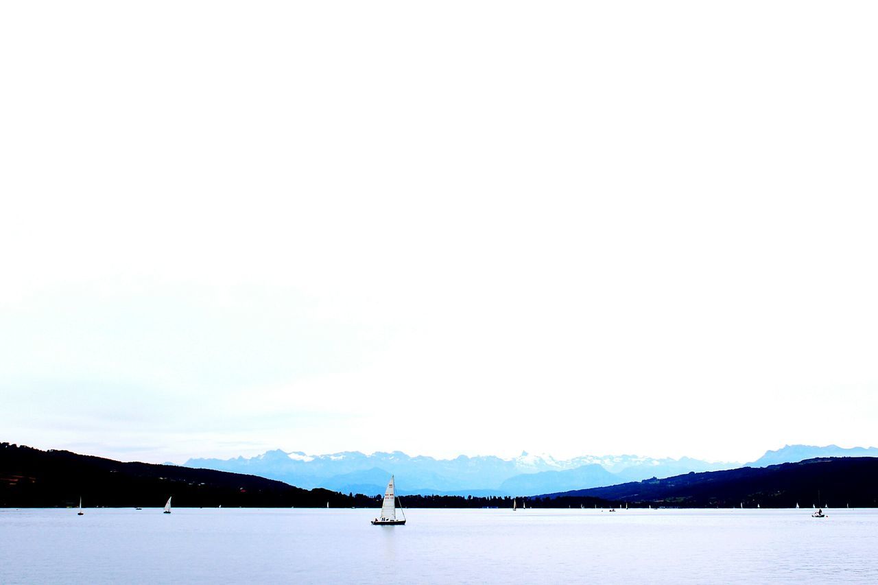 water, waterfront, clear sky, tranquil scene, mountain, tranquility, copy space, scenics, nautical vessel, sea, mountain range, nature, lake, beauty in nature, boat, transportation, idyllic, outdoors, day, no people