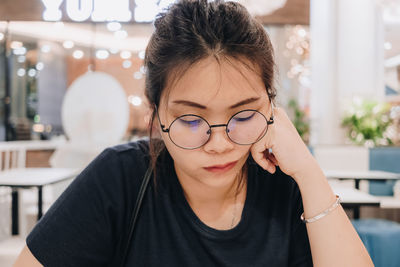 Close-up of woman sitting at shopping mall