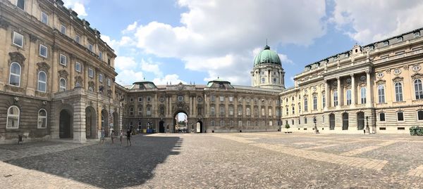 Buda castle in city against cloudy sky