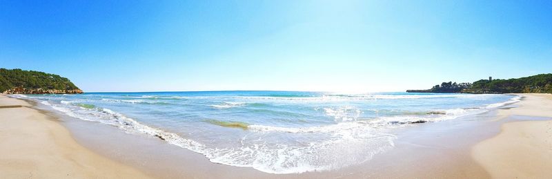 Panoramic shot of sea against clear blue sky