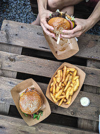 Eating beef burger with french fries outside