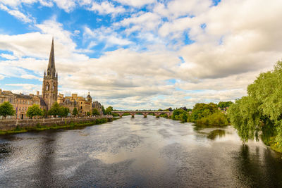 River in city against cloudy sky