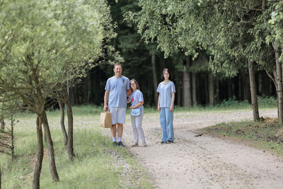 Dad and daughters on a walk in the summer forest