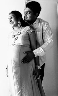 Young couple kissing against white background