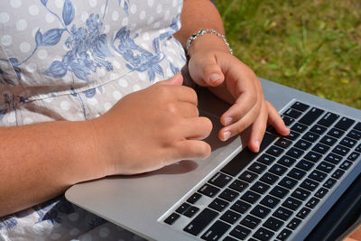 Close-up of girl using laptop outdoors