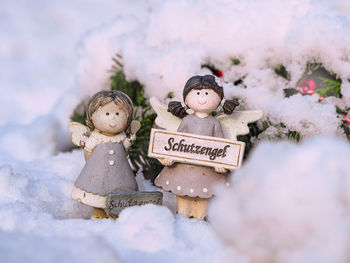 Stuffed toy on snow covered plants during winter