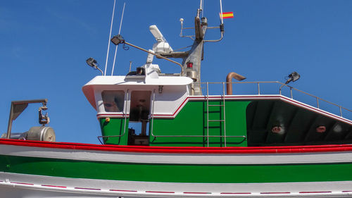 Low angle view of ship moored on sea against clear blue sky