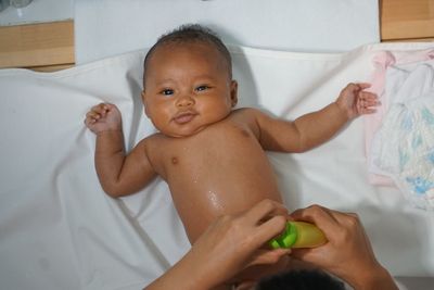 High angle view of baby girl on bed at home