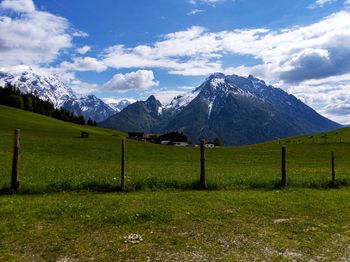 Scenic view of field and mountains against sky