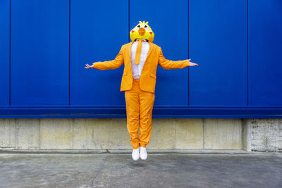 Full length of person standing against yellow wall