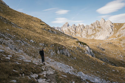 Man standing on land by mountain against sky