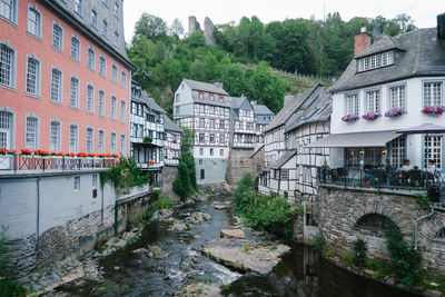 Buildings by river in city against sky