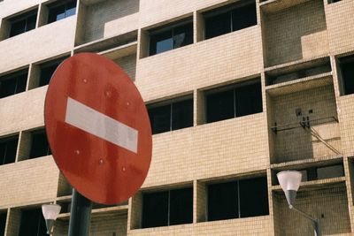 Low angle view of road sign against buildings in city